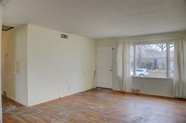 unfurnished room featuring a textured ceiling and hardwood / wood-style floors