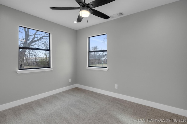 carpeted spare room featuring ceiling fan