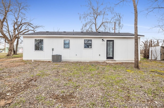 back of house with central AC unit and a lawn