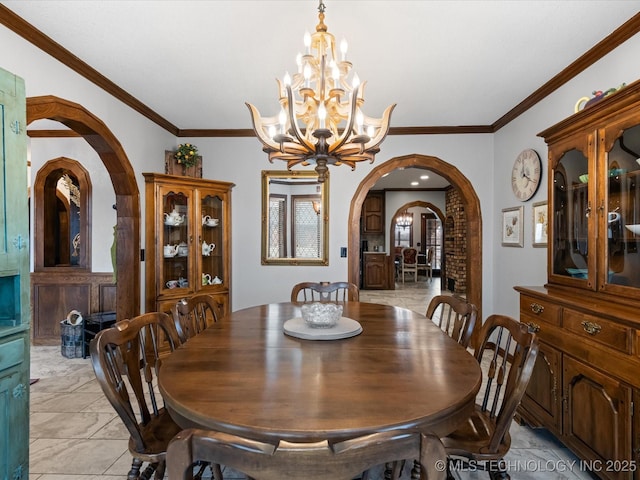 dining area with ornamental molding and a chandelier