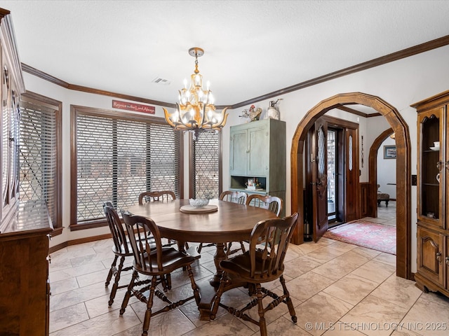 dining room featuring a textured ceiling, a notable chandelier, and ornamental molding