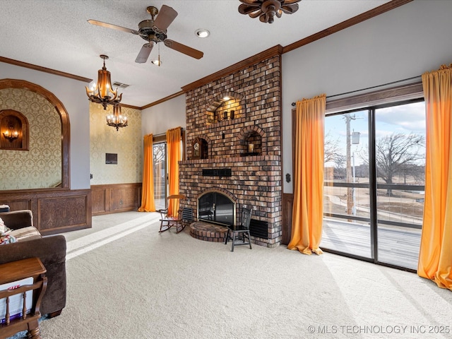 carpeted living room with a fireplace, ceiling fan, crown molding, and a textured ceiling