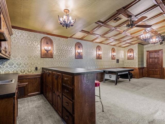 interior space with a kitchen breakfast bar, light carpet, sink, an inviting chandelier, and kitchen peninsula