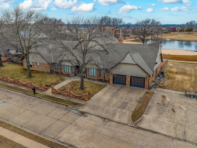 view of front of property with a water view, a front lawn, and a garage