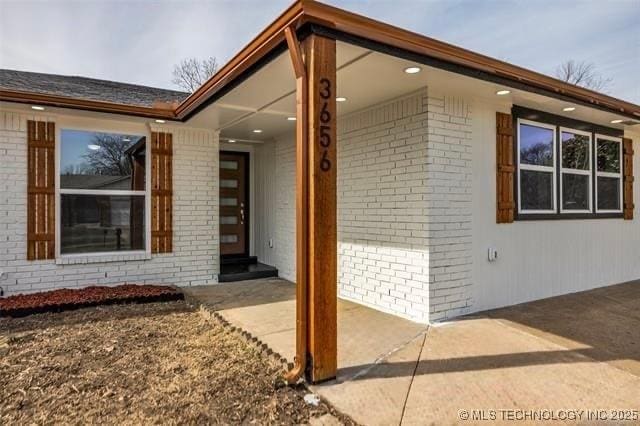 view of exterior entry featuring a patio