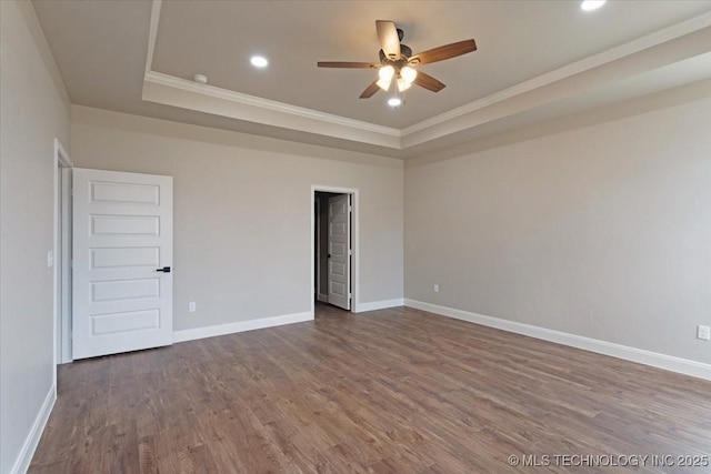 spare room with a tray ceiling, ornamental molding, ceiling fan, and wood-type flooring