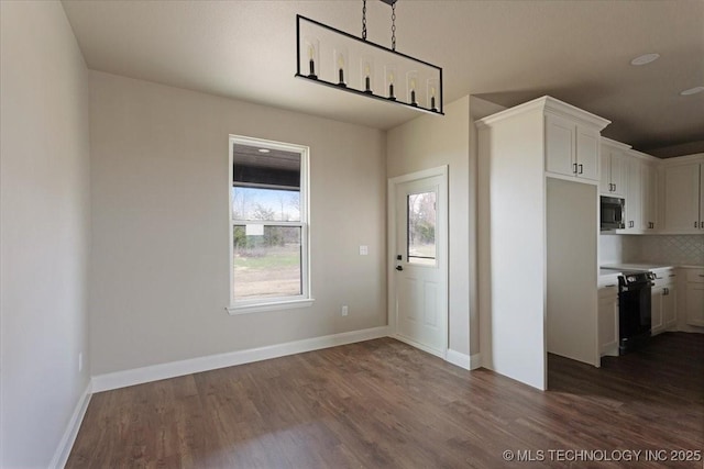 kitchen featuring white cabinets, black appliances, dark hardwood / wood-style floors, and decorative backsplash