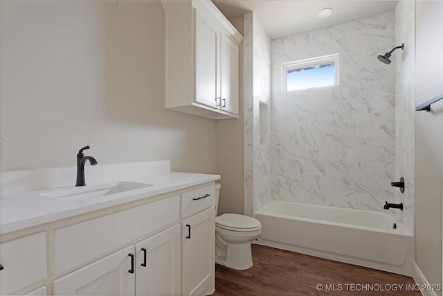 full bathroom with toilet, vanity, hardwood / wood-style floors, and tiled shower / bath combo