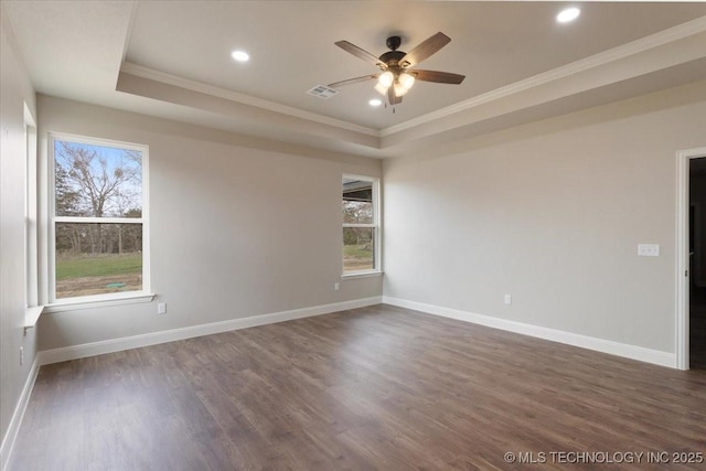 unfurnished room featuring dark hardwood / wood-style flooring, ceiling fan, crown molding, and a raised ceiling