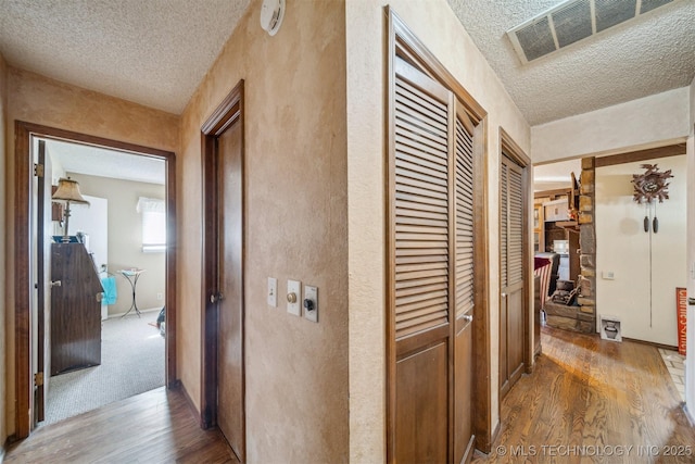 hall featuring hardwood / wood-style flooring and a textured ceiling