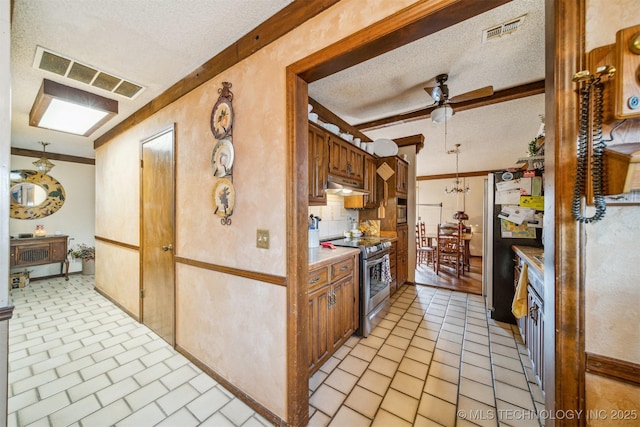 kitchen with a textured ceiling, appliances with stainless steel finishes, ceiling fan, and pendant lighting