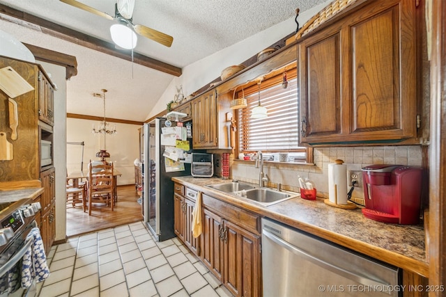 kitchen with appliances with stainless steel finishes, sink, pendant lighting, and lofted ceiling with beams