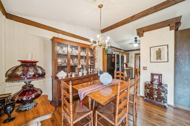 dining space featuring a textured ceiling, vaulted ceiling with beams, a notable chandelier, and wood-type flooring