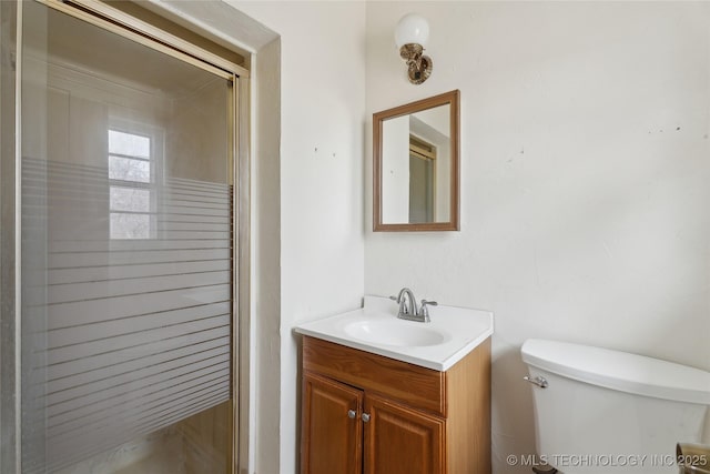 bathroom featuring vanity, an enclosed shower, and toilet