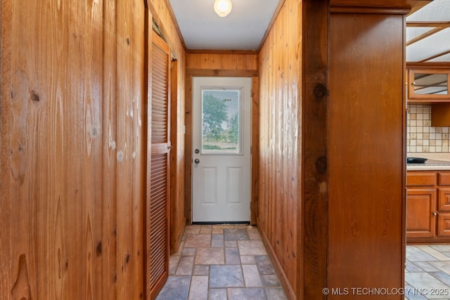 doorway with wooden walls and ornamental molding