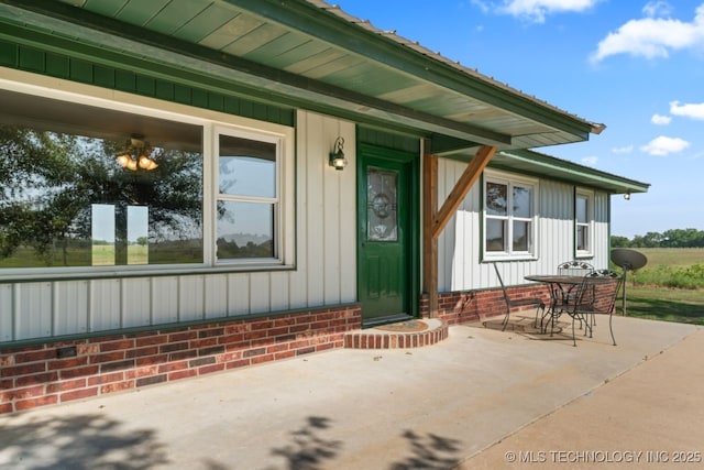 view of exterior entry featuring a patio and board and batten siding