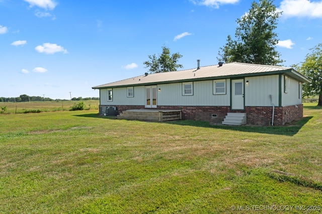 rear view of property featuring french doors and a yard