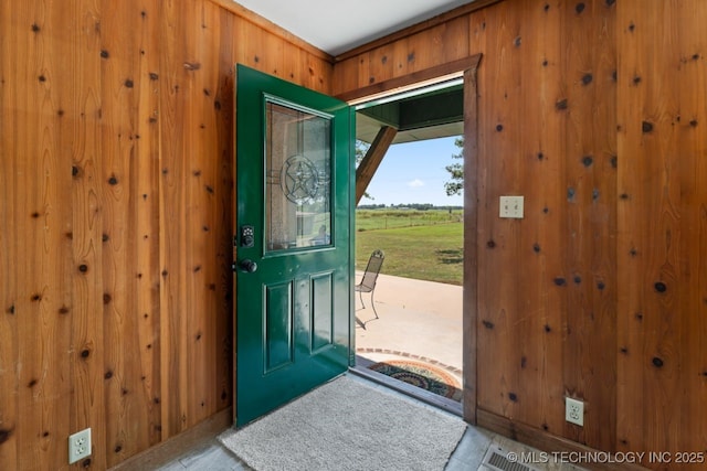 entryway with wood walls