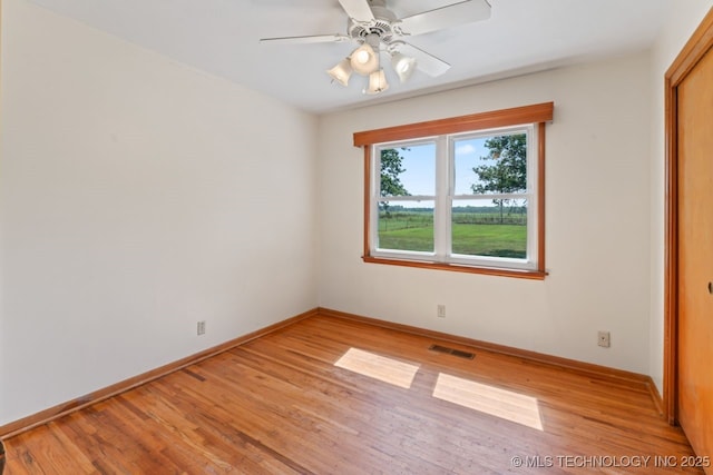 empty room featuring ceiling fan and light hardwood / wood-style floors