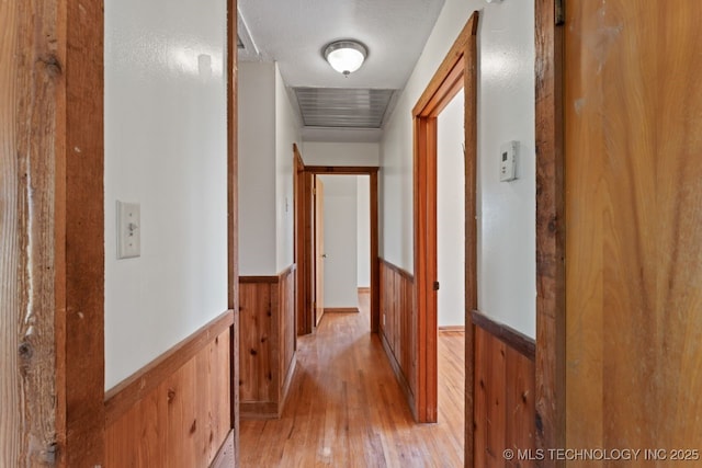 hall featuring wooden walls and light hardwood / wood-style flooring