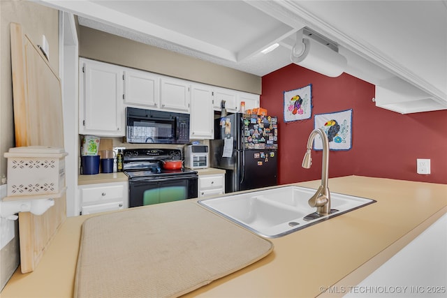 kitchen featuring a sink, black appliances, light countertops, and white cabinetry