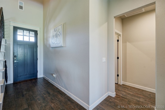 foyer entrance with dark wood-style flooring, visible vents, and baseboards