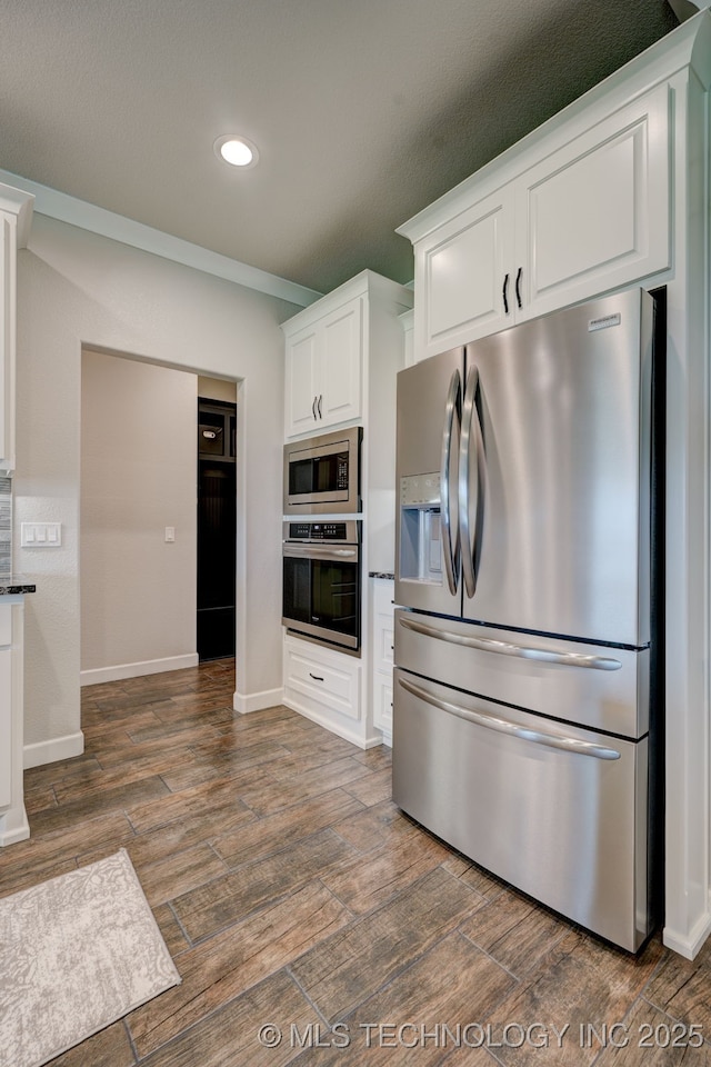 kitchen with appliances with stainless steel finishes, recessed lighting, white cabinetry, and dark wood-style floors