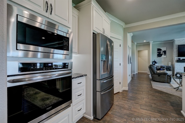 kitchen with white cabinetry, stainless steel appliances, crown molding, and open floor plan