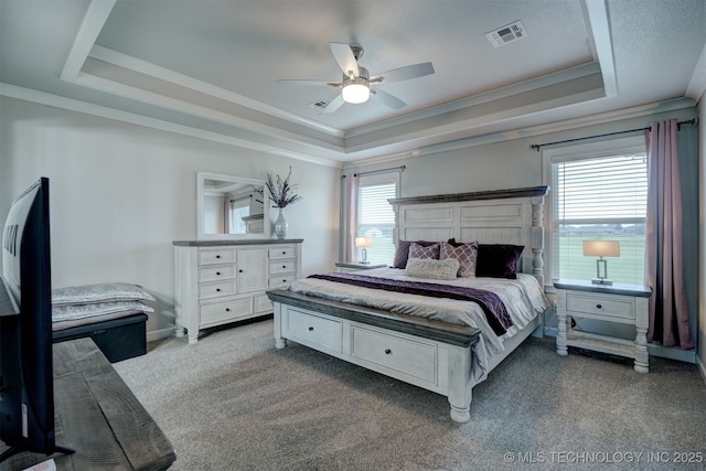 bedroom with carpet, a raised ceiling, and visible vents