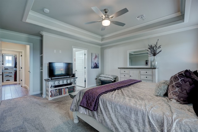 bedroom with light carpet, baseboards, a tray ceiling, and crown molding