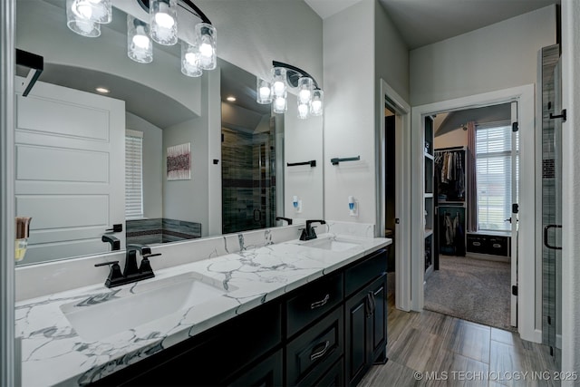 full bath featuring a spacious closet, a sink, and a shower stall