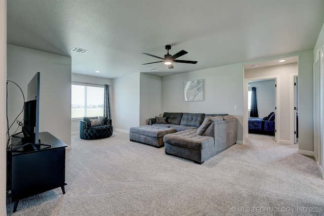 living area with baseboards, visible vents, a ceiling fan, light colored carpet, and a textured ceiling