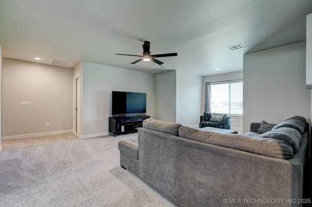 living room featuring light colored carpet, visible vents, a textured ceiling, and baseboards