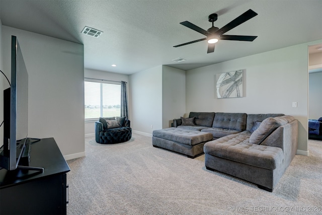 living room featuring a textured ceiling, baseboards, visible vents, and light colored carpet