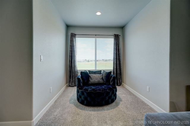 sitting room featuring carpet floors and baseboards