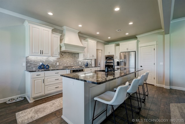 kitchen featuring white cabinets, a spacious island, premium range hood, and stainless steel appliances