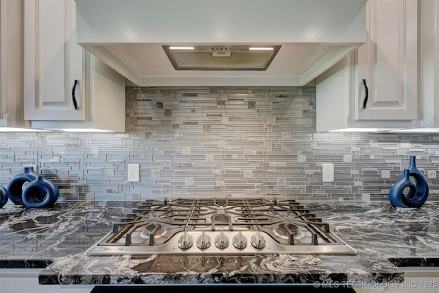 kitchen with white cabinetry, premium range hood, stainless steel gas cooktop, and tasteful backsplash