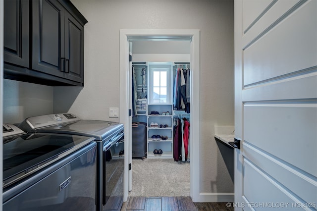 clothes washing area featuring cabinet space, a textured wall, dark wood finished floors, and washing machine and clothes dryer