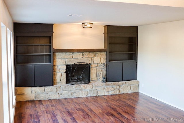 unfurnished living room with a fireplace, dark hardwood / wood-style floors, and built in features