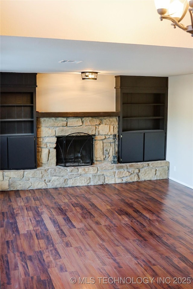 unfurnished living room with a fireplace, built in shelves, and hardwood / wood-style flooring