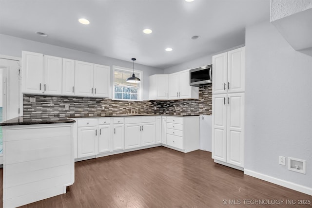 kitchen with decorative light fixtures, dark hardwood / wood-style floors, and white cabinets