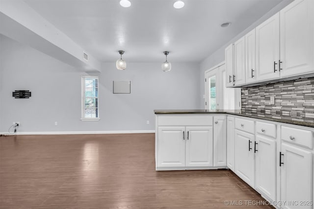 kitchen featuring white cabinetry, tasteful backsplash, dark hardwood / wood-style floors, and decorative light fixtures