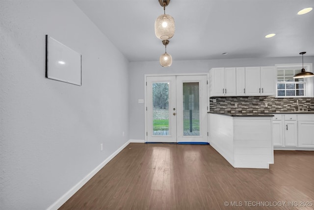 kitchen with pendant lighting, white cabinetry, dark hardwood / wood-style floors, french doors, and decorative backsplash