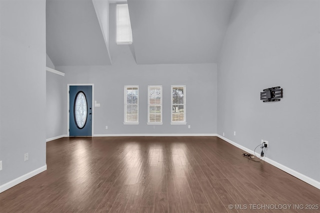 unfurnished living room featuring hardwood / wood-style floors and a high ceiling