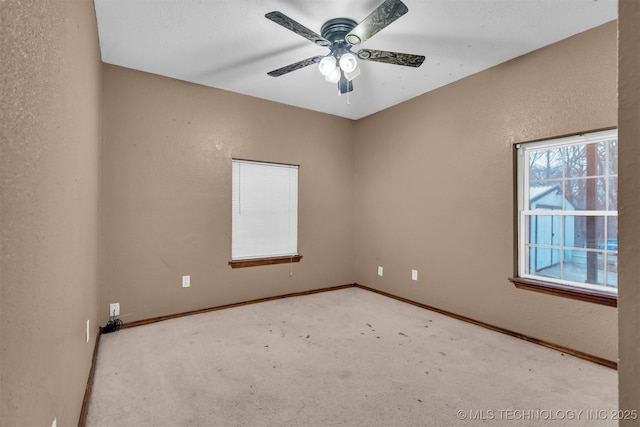 carpeted spare room with ceiling fan