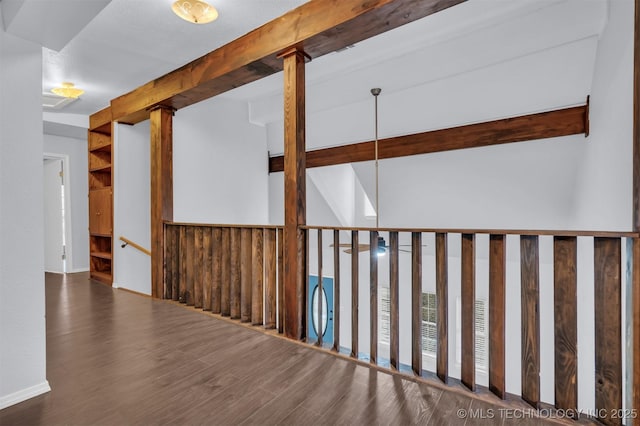 empty room with dark hardwood / wood-style floors and beam ceiling