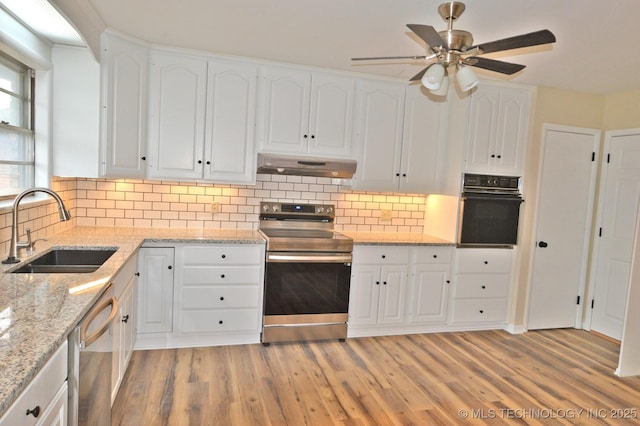 kitchen featuring appliances with stainless steel finishes, white cabinets, a sink, and under cabinet range hood