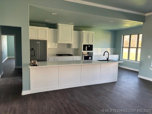 kitchen with dark wood finished floors, light countertops, white cabinets, refrigerator with ice dispenser, and oven