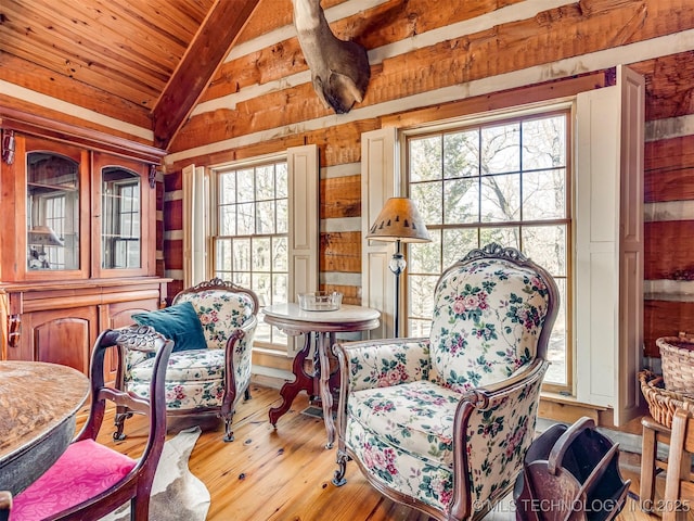 living area featuring light hardwood / wood-style floors, wooden ceiling, and lofted ceiling with beams