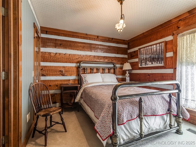 carpeted bedroom with wood walls